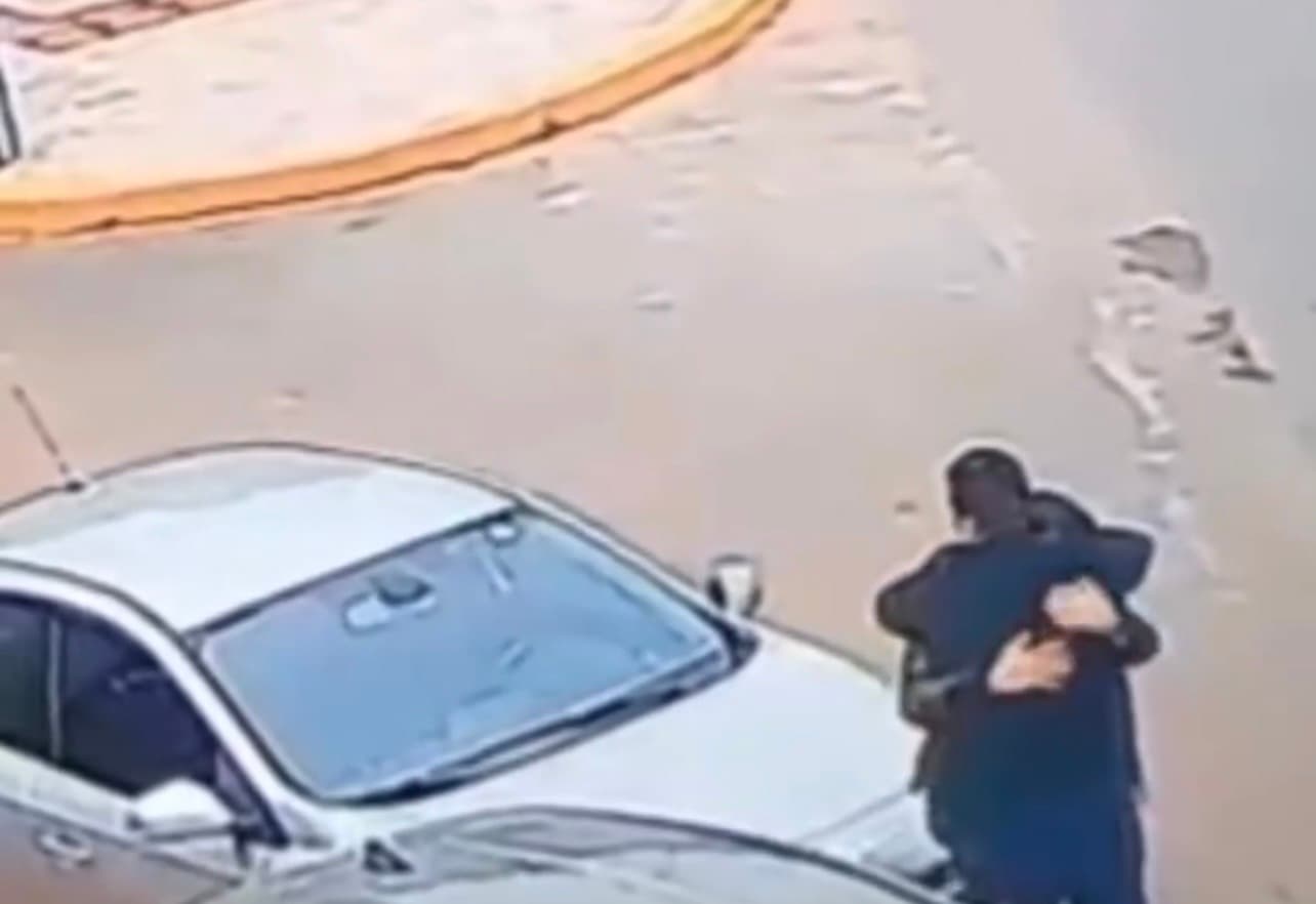 Motoristas se abraçam logo após batida de carro